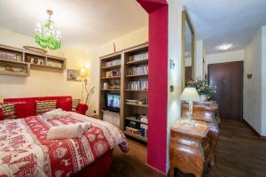a bedroom with a red bed and a book shelf at Baita La Ciaburna skiing nearby - Happy Rentals in Bardonecchia