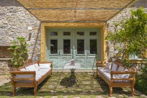 un patio con 2 sillas y una puerta verde en Samos Wine Factory Guesthouse Villa en Karlovasi