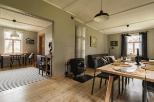 a living room with a table and a fireplace at Newly renovated Latvian farm house in Kraujas