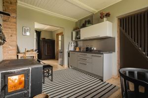 a kitchen with a fireplace and a stove at Newly renovated Latvian farm house in Kraujas