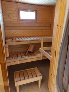 a wooden sauna with a bench and a window at Apartment Kamreerintie in Laihia