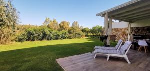 錫尼斯科拉的住宿－Green House，庭院设有两把椅子和一张桌子。