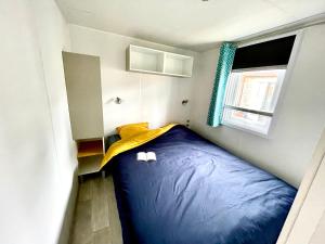 a small bedroom with a blue sleeping bag in it at Spacieux Mobilhome Premium/Camping 5* in Vendays-Montalivet