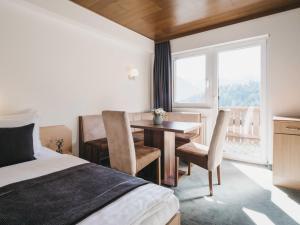 pokój hotelowy z łóżkiem, stołem i krzesłami w obiekcie Haus Bellevue by VAYA inklusive Super Sommer Card w mieście Serfaus