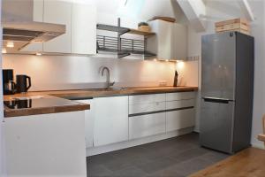 a kitchen with white cabinets and a stainless steel refrigerator at Heuboden in Geschendorf