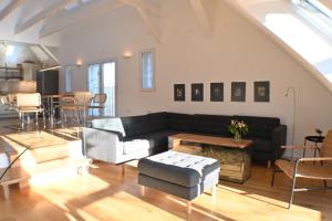 a living room with a black couch and a table at Heuboden in Geschendorf