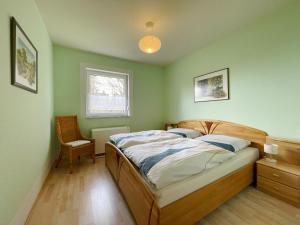 um quarto com uma cama e uma cadeira em Bungalow am Waldesrand/ Haus Konrad em Suhl