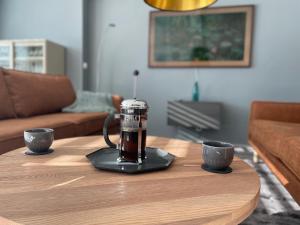 a coffee maker on a table with two cups on it at Emma Gjestehus in Sandvika