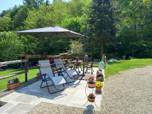 patio con tavolo, sedie e ombrellone di Natura e relax a Barge