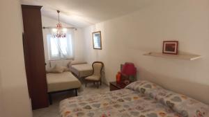 ein Schlafzimmer mit einem Bett, einem Stuhl und einem Fenster in der Unterkunft Casa Michela in Vico del Gargano