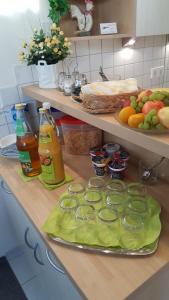 a kitchen counter with fruits and vegetables and juice at Pension Grasy in Aidlingen