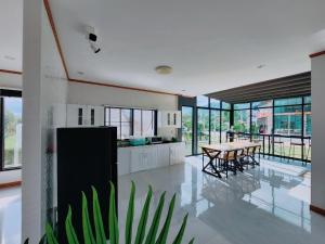 a kitchen and dining room with a table and chairs at Kerepiman Boutique Hotel in Khao Kho