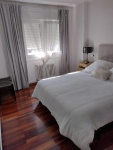 1 dormitorio con cama blanca y ventana en MAXIMO CONFORT en Lugo