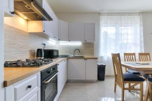 a kitchen with white cabinets and a table and a counter top at Apartment Luka in Senj
