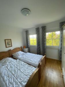 a bedroom with a large bed and two windows at Ferienhaus Weißburgunder am Weinberg in Naumburg