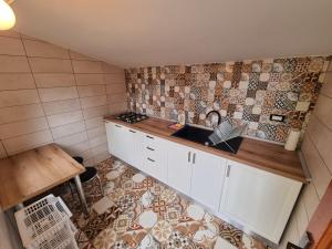 a kitchen with a sink and a tile floor at Casa Agapie in Uzlina
