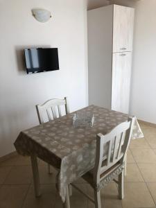 een eettafel met 2 stoelen en een televisie bij Residenza FILIPPO in Tropea