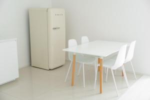 uma mesa branca e cadeiras ao lado de um frigorífico em Piestany Waltari Apartment em Piešťany