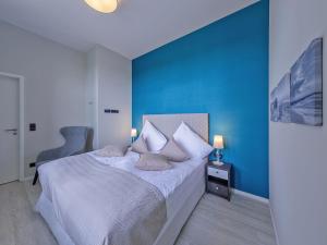 um quarto com uma cama com uma parede azul em Panorama-Utkiek em Wustrow