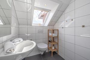 a white bathroom with a sink and a toilet at Appartementhaus Gouverneur-Maxse Büsum in Büsum +101 photos