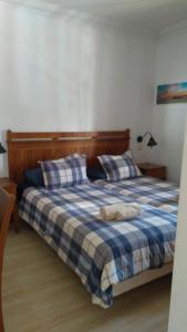een slaapkamer met een bed met een blauwe en witte geruite deken bij Apartment in the City Center near to the beach in Puerto del Carmen