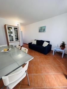 un soggiorno con un tavolo di vetro e un divano di Casa Carolina a Torre Pali