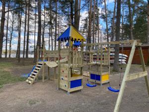 un parque infantil de madera con un tobogán y un columpio en Domki Letniskowe Ośmiorniczka en Augustów