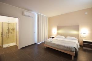 a bedroom with a bed and a walk in shower at Hotel La Siesta in Torino di Sangro