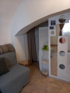 a living room with a couch and a mirror at Bunari Studio Apartment in Rovinj