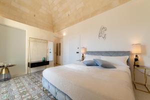 - une chambre avec un grand lit blanc et des oreillers bleus dans l'établissement Palazzo Virgintino - Sassi Rooms, à Matera