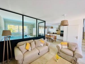 a living room with two couches and a kitchen at Les Jardins du Castelas by Perier-Provence in Uchaux