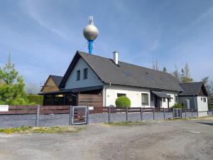 a white house with a water tower on top of it at Apartmány Pod Koulí in Domanín