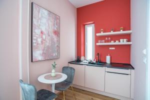 a kitchen with red walls and a table and chairs at Center De Lux Studios “ Zara “ in Split
