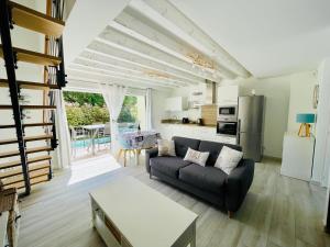 a living room with a couch and a kitchen at Les Jardins du Castelas by Perier-Provence in Uchaux