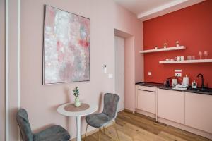 a kitchen with red walls and a table and chairs at Center De Lux Studios “ Zara “ in Split