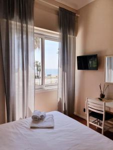 a bedroom with a bed and a window and a table at Vela Bianca H & R in Diano Marina