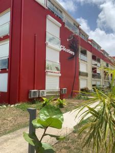 un edificio rojo y blanco con una planta delante en Marigot, Studio front de mer vue exceptionnelle, en Marigot