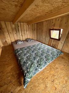 a bed in a wooden cabin with a window at Bouda Orlí Hnízdo in Němčovice
