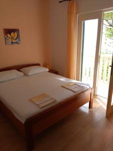 Un dormitorio con una cama y una puerta corrediza de vidrio. en Apartments Elvira, en Sveta Nedelja