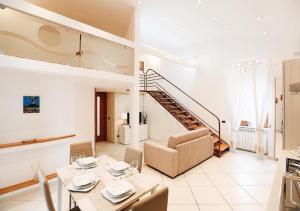 Maison Mele Luxury Apartment في نابولي: غرفة معيشة مع طاولة طعام ودرج