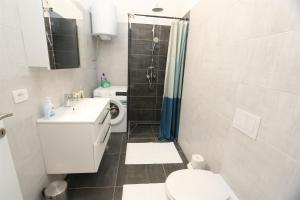 a bathroom with a toilet and a sink and a shower at Apartments Zabcic in Soline