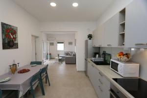 a kitchen with white cabinets and a table with a microwave at Apartments Zabcic in Soline