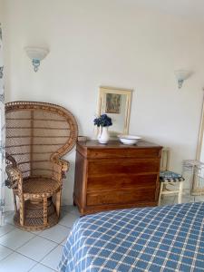 sypialnia z łóżkiem, krzesłem i komodą w obiekcie Casa sul mare- House on the sea- VERSILIA w mieście Marina di Pietrasanta