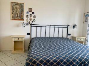 a bedroom with a bed with a blue checked comforter at Casa sul mare- House on the sea- VERSILIA in Marina di Pietrasanta