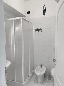 La salle de bains blanche est pourvue d'une douche et de toilettes. dans l'établissement Casa sul mare- House on the sea- VERSILIA, à Marina di Pietrasanta