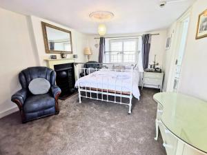 a bedroom with a bed and a chair at The Darlington in Camelford