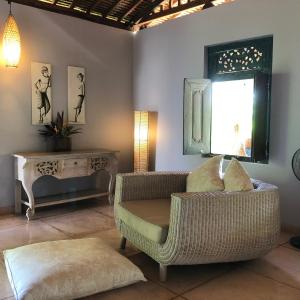 Una sala de estar con una silla y una mesa. en Villa KAROUNA, en Sukawati