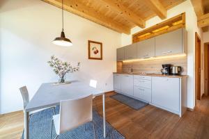 cocina y comedor con mesa y sillas en Mayrhof Apartment Im Kirschgarten, en San Pancrazio