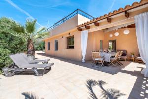 un patio con sillas y una mesa en una casa en Casa Antonio, en Cala Llombards