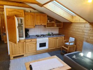 a kitchen with wooden cabinets and a stove at Schöne Ferienwohnung im Naturpark Grebenzen in Sankt Lambrecht